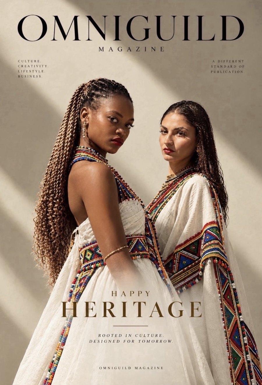 Omniguild Heritage Day cover: two women in beaded, embroidered white dress against a sunlit wall